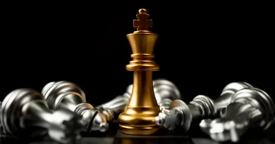 Rei dourado em destaque entre peças caídas. Símbolo de vitória e estratégia.