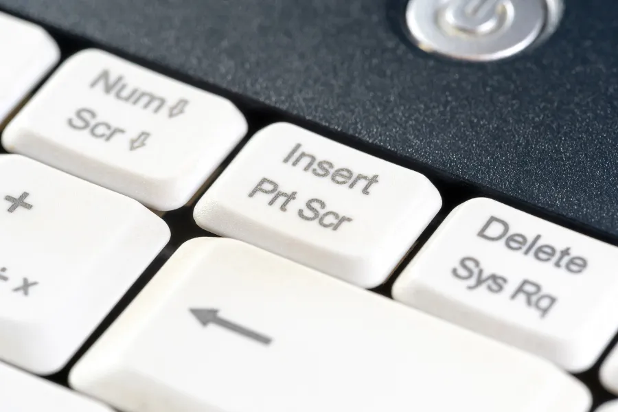 Tecla "Print Screen" em teclado branco, pronta para capturar tela.