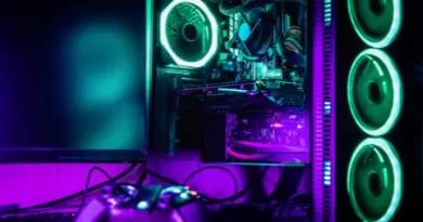 PC gamer ligado com luzes RGB verdes e roxas, gabinete transparente, controle de videogame no primeiro plano