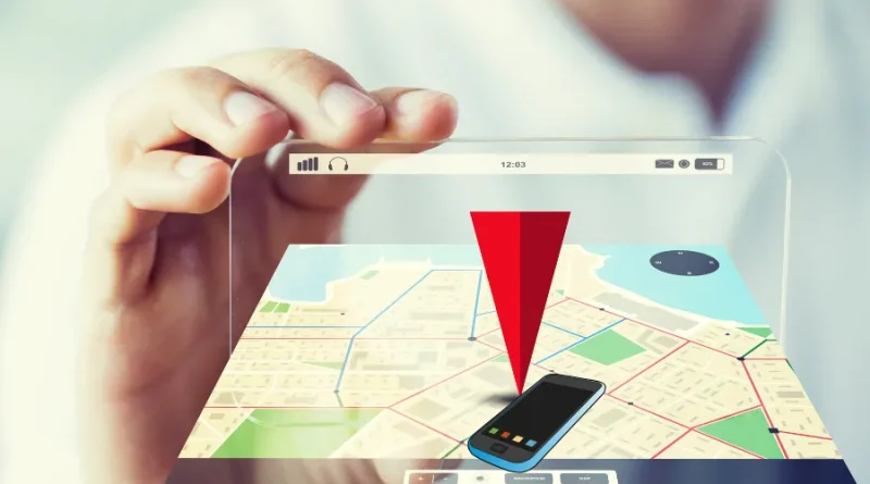Mão segurando um dispositivo transparente com mapa e um pino de localização vermelho apontando para um celular