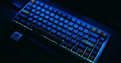 Teclado mecânico gamer escuro iluminado com luzes RGB neon azuis e laranjas