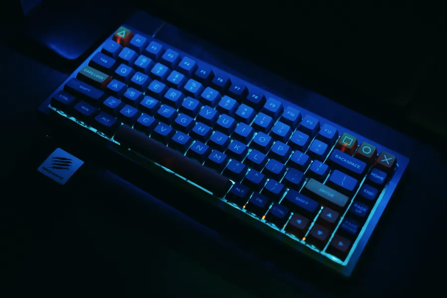 Teclado mecânico gamer escuro iluminado com luzes RGB neon azuis e laranjas