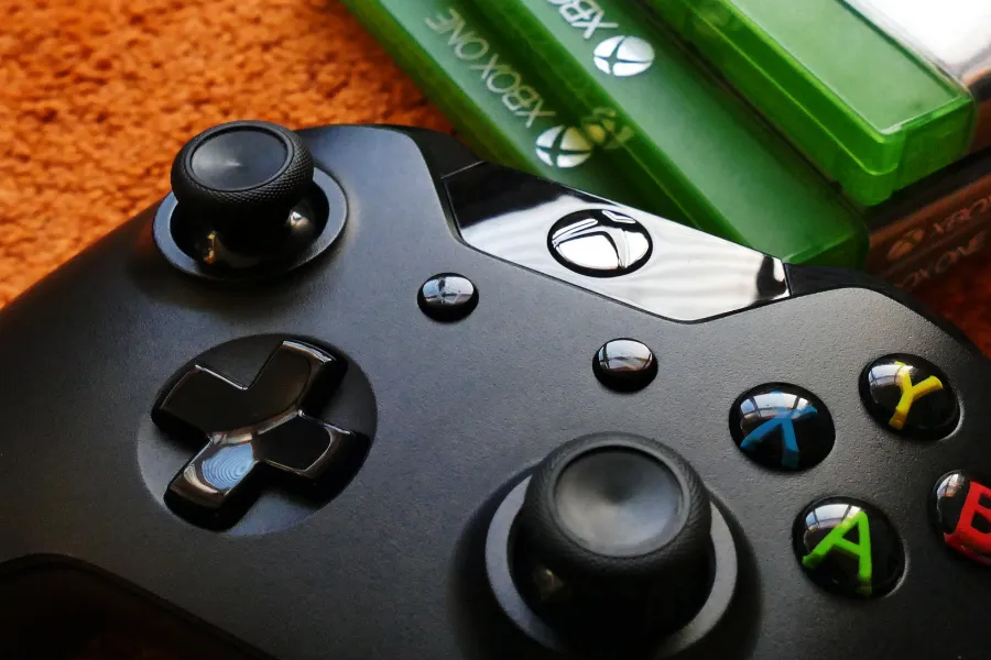 Controle do Xbox com botões coloridos, representando o serviço Xbox Game Pass e a assinatura de jogos em 2025.