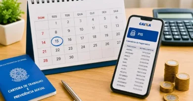 Calendário de mesa com data destacada ao lado de celular exibindo informações do PIS, carteira de trabalho e moedas.