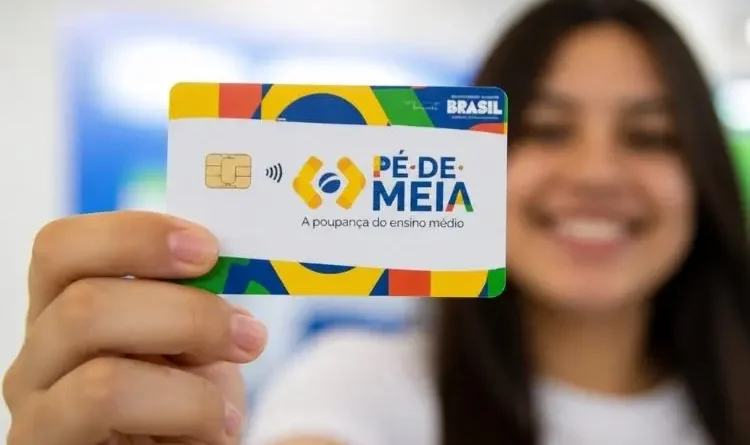 ovem segurando cartão do programa com fundo desfocado